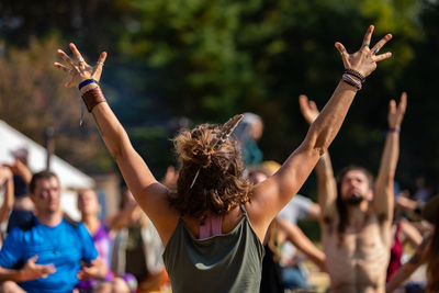 Midsection of woman with arms raised in music concert