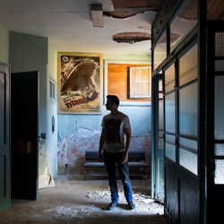 Rear view of man standing at entrance of building