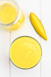 High angle view of yellow drink on table