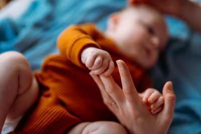 Baby holding hand at home