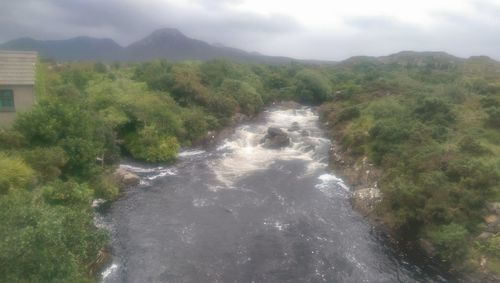 Scenic view of waterfall against sky