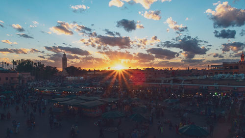 People on street against sky during sunset