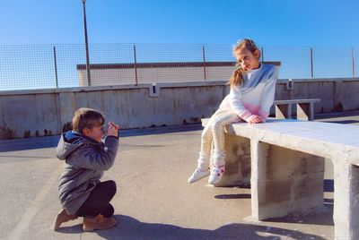 Full length of girl sitting outdoors