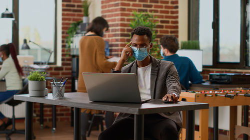 Young woman using laptop at cafe