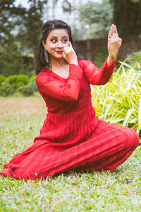 Portrait of a smiling young woman sitting on field