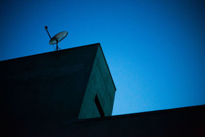 Low angle view of antenna against clear blue sky