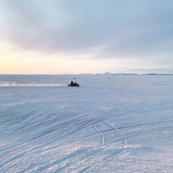 Man snowmobiling on snow covered landscape