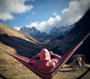 Man lying down on land against sky