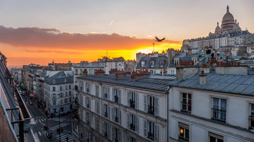 Buildings and basilique du sacre coeur against sky at sunset