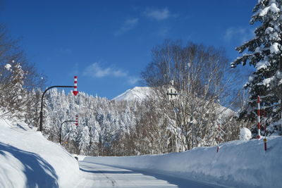 Snow covered land and mountains against blue sky