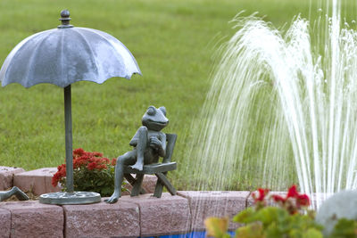 A statue of a frog next to a fountain.