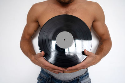 Midsection of man holding camera against white background