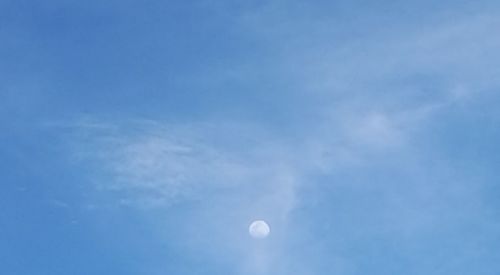 Low angle view of moon in blue sky