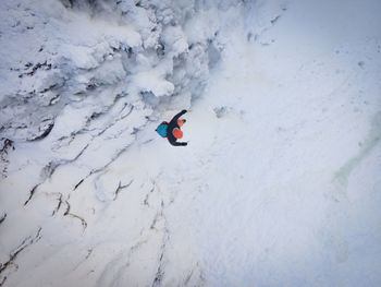 High angle view of man walking on snowcapped land