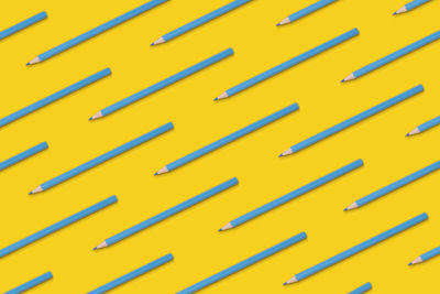 Pattern composition of blue pencils on a yellow background. top view. flat lay.