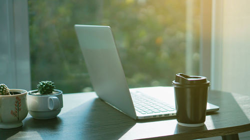 Coffee cup on table by window at home