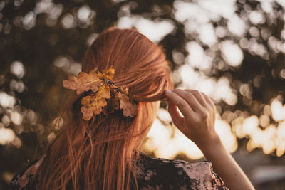 Rear view of woman with leaves in hair
