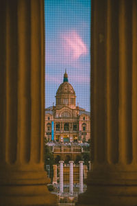 Buildings against sky seen through window