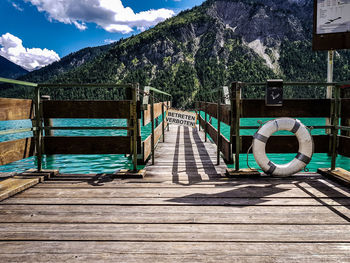 Boardwalk amidst trees against sky