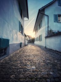 Footpath amidst buildings against sky