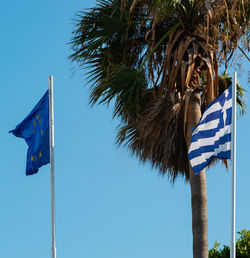 Low angle view of palm trees against blue sky