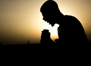 Close-up portrait of silhouette man against sky during sunset