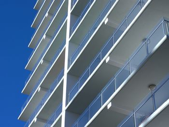 Low angle view of modern building against blue sky