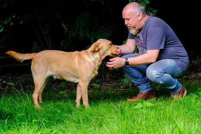 Side view of man with dog on grass