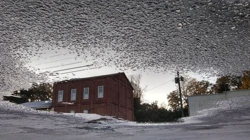 Road by building against clear sky during winter