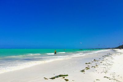 Scenic view of beach against clear blue sky