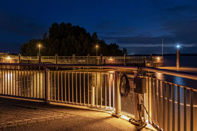 Light trails on bridge against sky at night