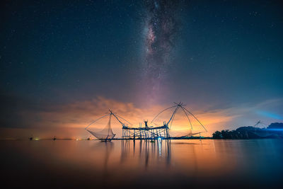 Sailboats in sea against sky at night