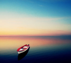 Scenic view of boat in seascape during sunset