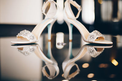 Close-up of rings and sandals on glass table