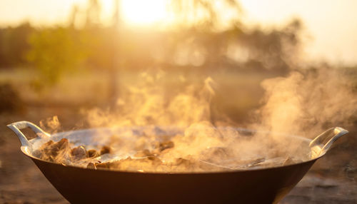 Close-up of fire in bowl at sunset