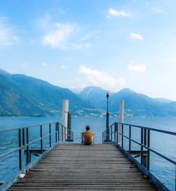 Pier on sea with mountain in background