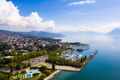 High angle view of townscape by sea against sky