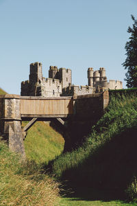 Low angle view of foot bridge and arundel castle against clear sky