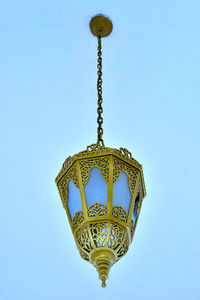 Low angle view of electric lamp against blue sky