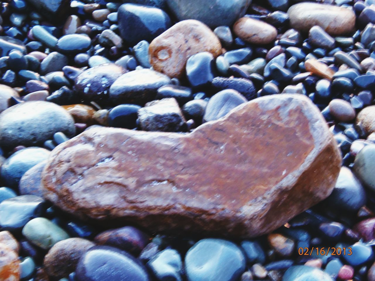 pebble, stone - object, beach, rock - object, nature, close-up, textured, tranquility, shore, backgrounds, stone, beauty in nature, natural pattern, full frame, water, day, abundance, sand, outdoors, rock