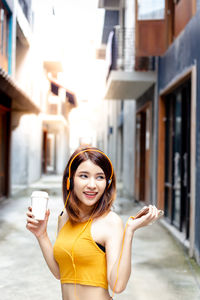 Portrait of a smiling young woman holding drink