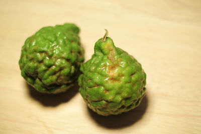 Close-up of kaffir limes on wooden table