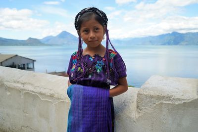 Portrait of girl standing against sky