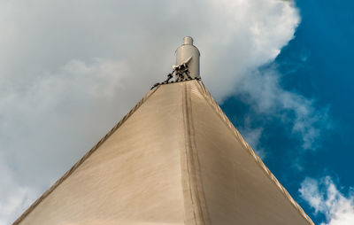 Low angle view of cross on building against sky