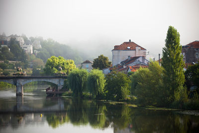 Bridge over river in city against clear sky