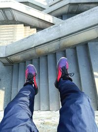 Low section of man wearing shoes on bridge