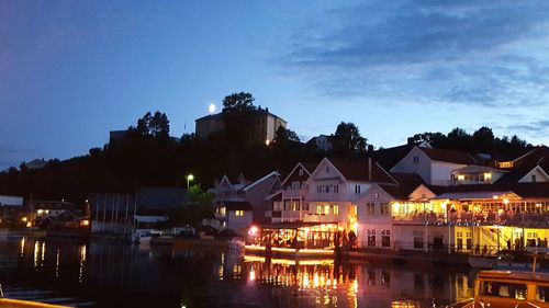 Illuminated buildings against sky at night