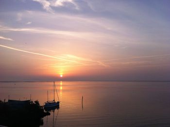 Boats sailing on sea against sky during sunset