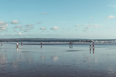 People on beach against sky