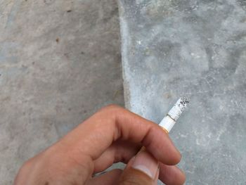 Close-up of hand holding cigarette